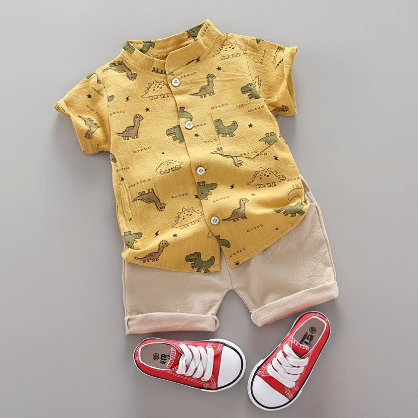 Children's outfit with yellow shirt and beige shorts, accompanied by red sneakers on a gray surface.